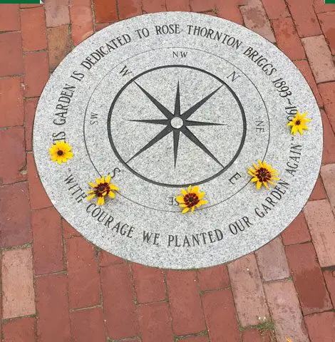 A compass with flowers on it is shown.